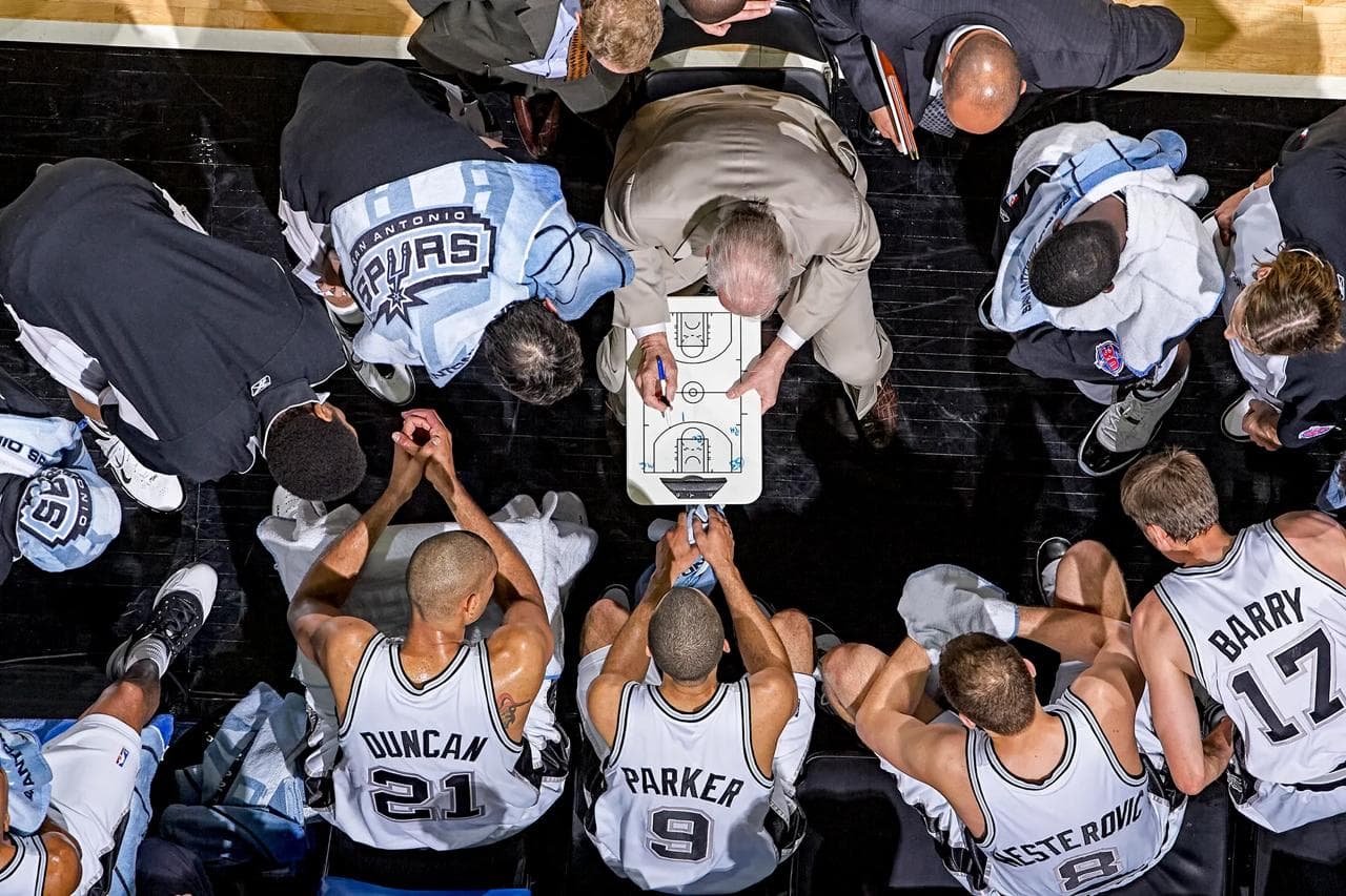 Coach teaching basketball tactics to students
